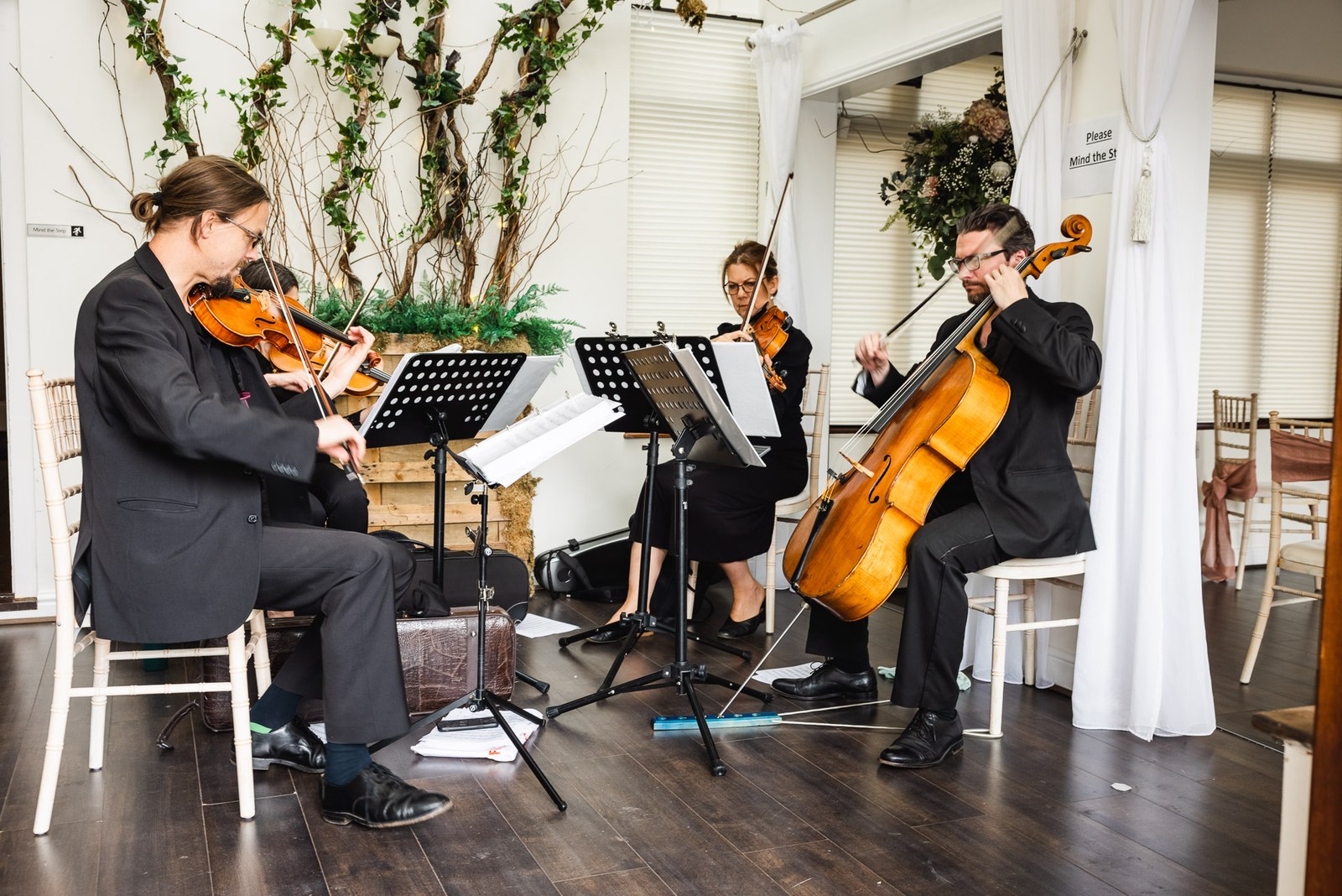 A string trio of two violins and a cello playing at Steventon House Hotel