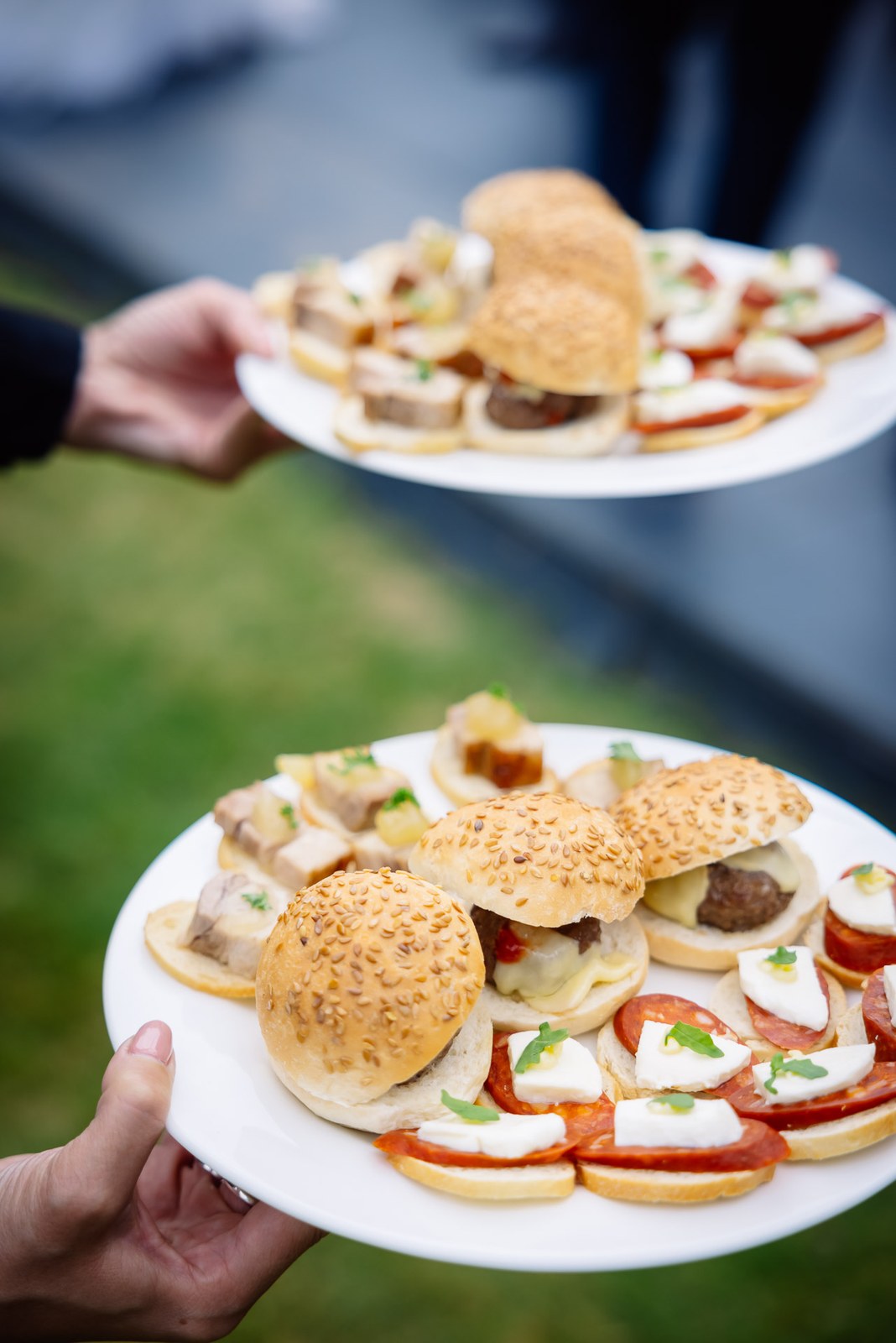 A tray of canapes - mini burgers and bruschetta - offered to guests