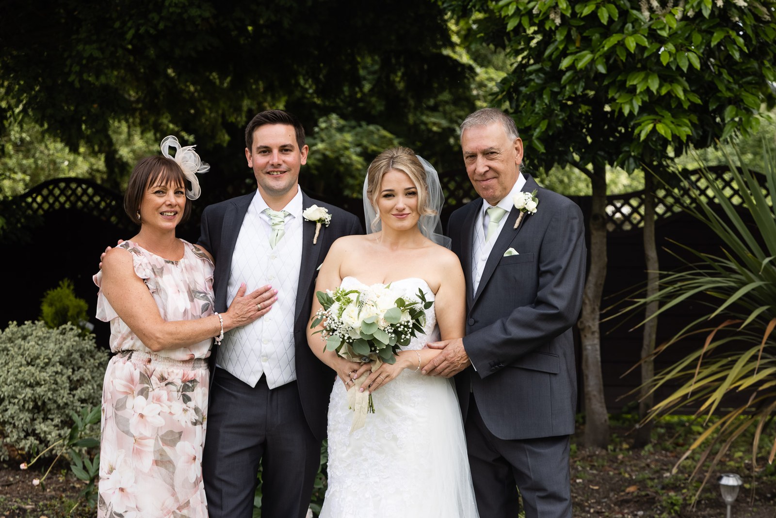 Family group portrait with the couple and parents in the Steventon House Hotel garden