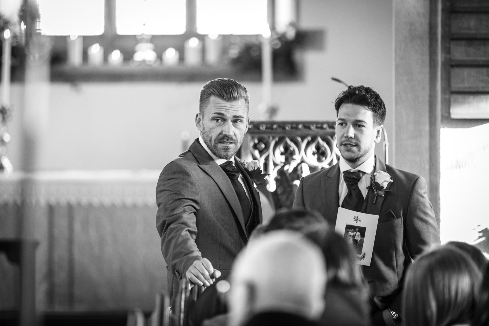 Black and white portrait of the groom and best man waiting at the front