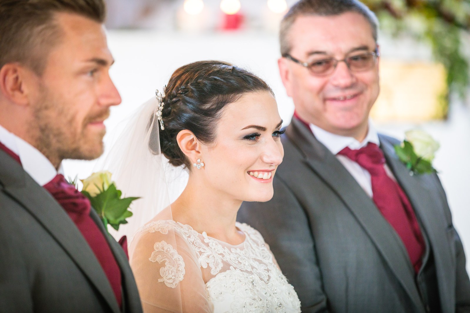 Bride glances up beside her father as the groom stands in profile