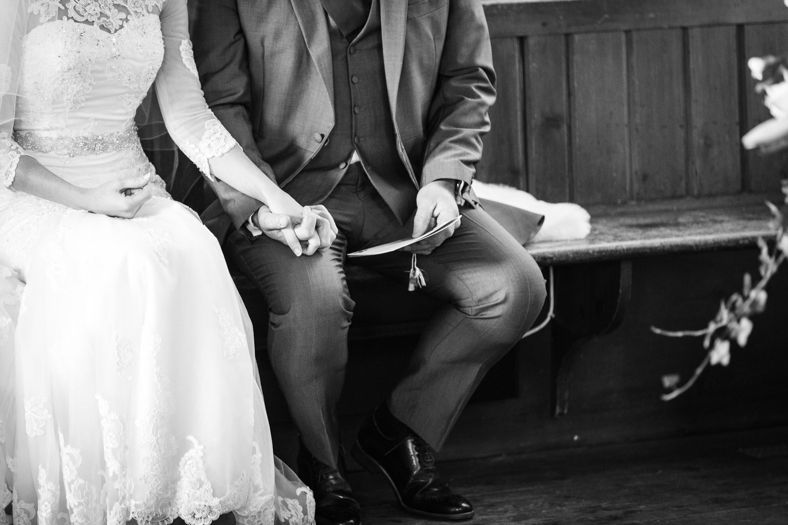 Black and white of the couple seated together on a church pew