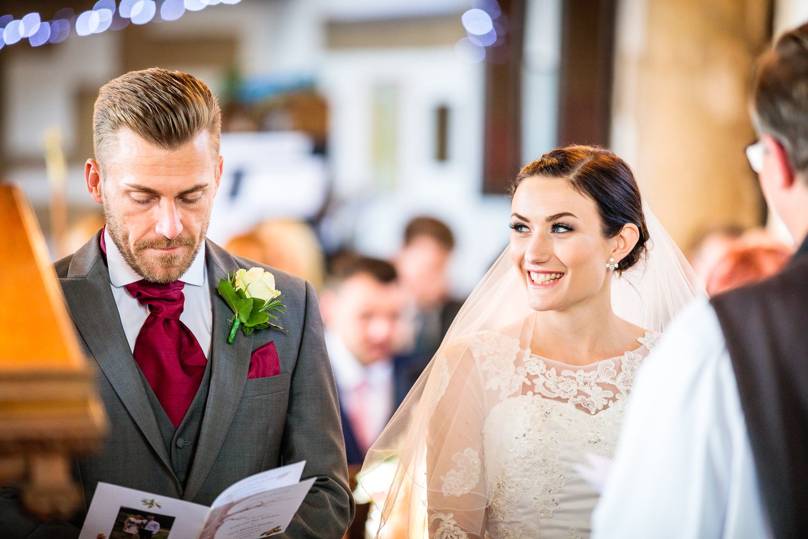 Bride and groom smile at each other during the church service