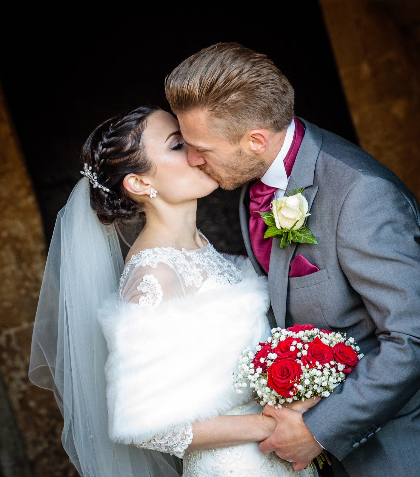 Close-up of the couple kissing, the bride wrapped in her fur stole