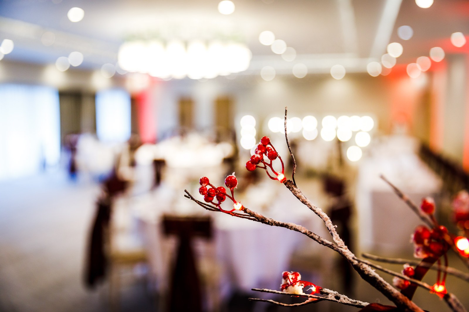 A berry-branch table decoration glows before the softly lit reception room