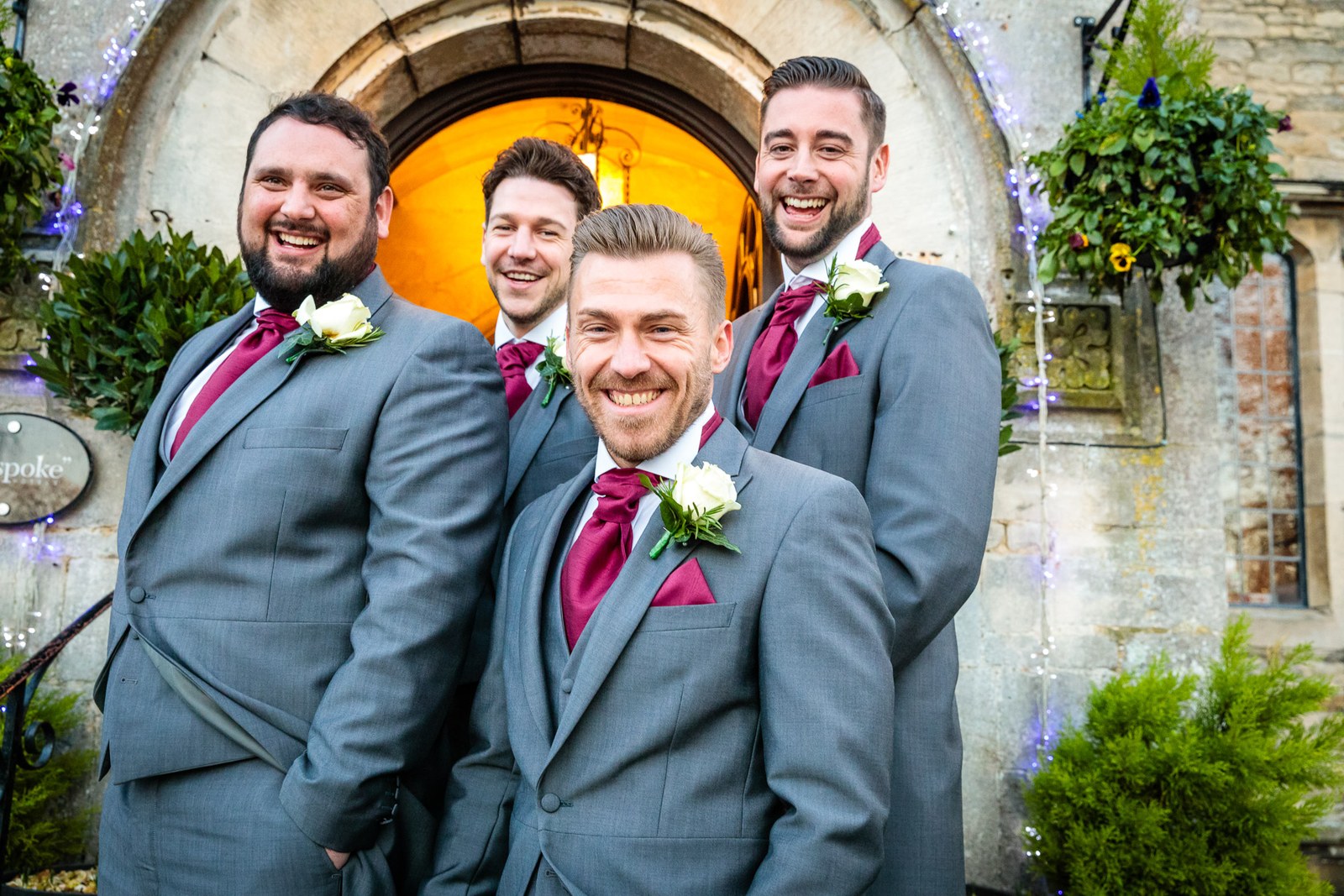 The groom and his groomsmen share a laugh before the Stonehouse Court Hotel entrance