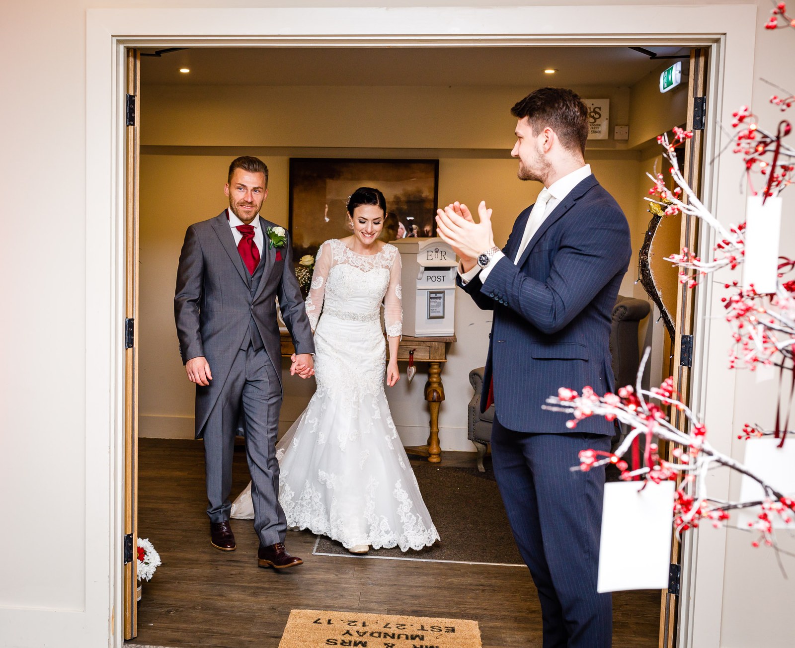 The newlyweds enter the reception room to applause from a guest