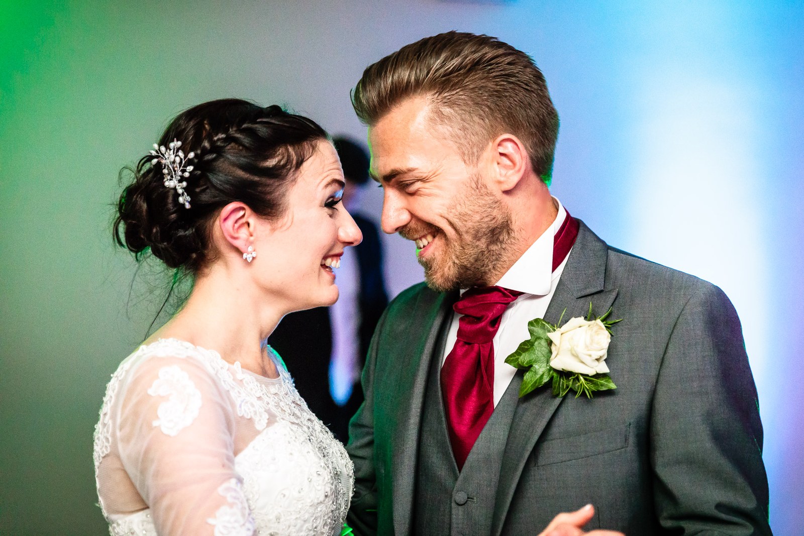 Bride and groom share their first dance under green and blue light