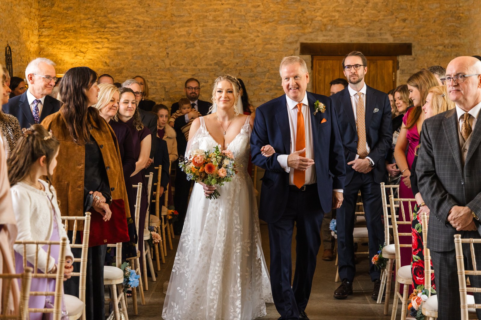 The bride coming down the aisle on her father's arm at Stratton Court Barn.