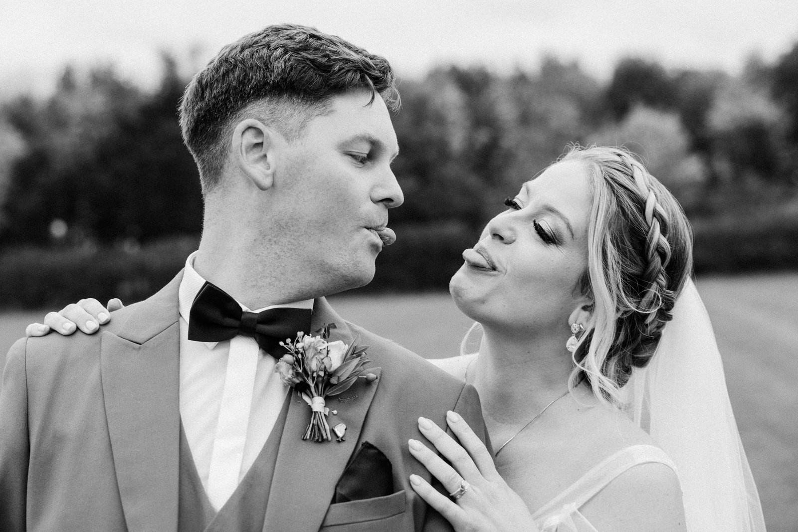 Black and white frame of the couple pulling faces at each other, close together.