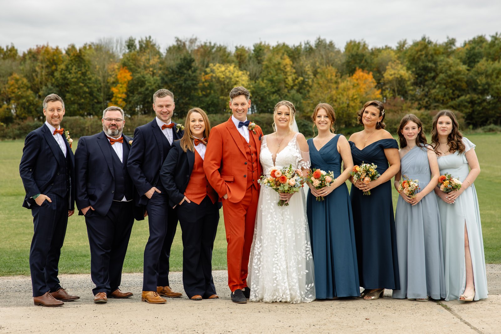 The whole wedding party lined up on the road beside the field at Stratton Court Barn.