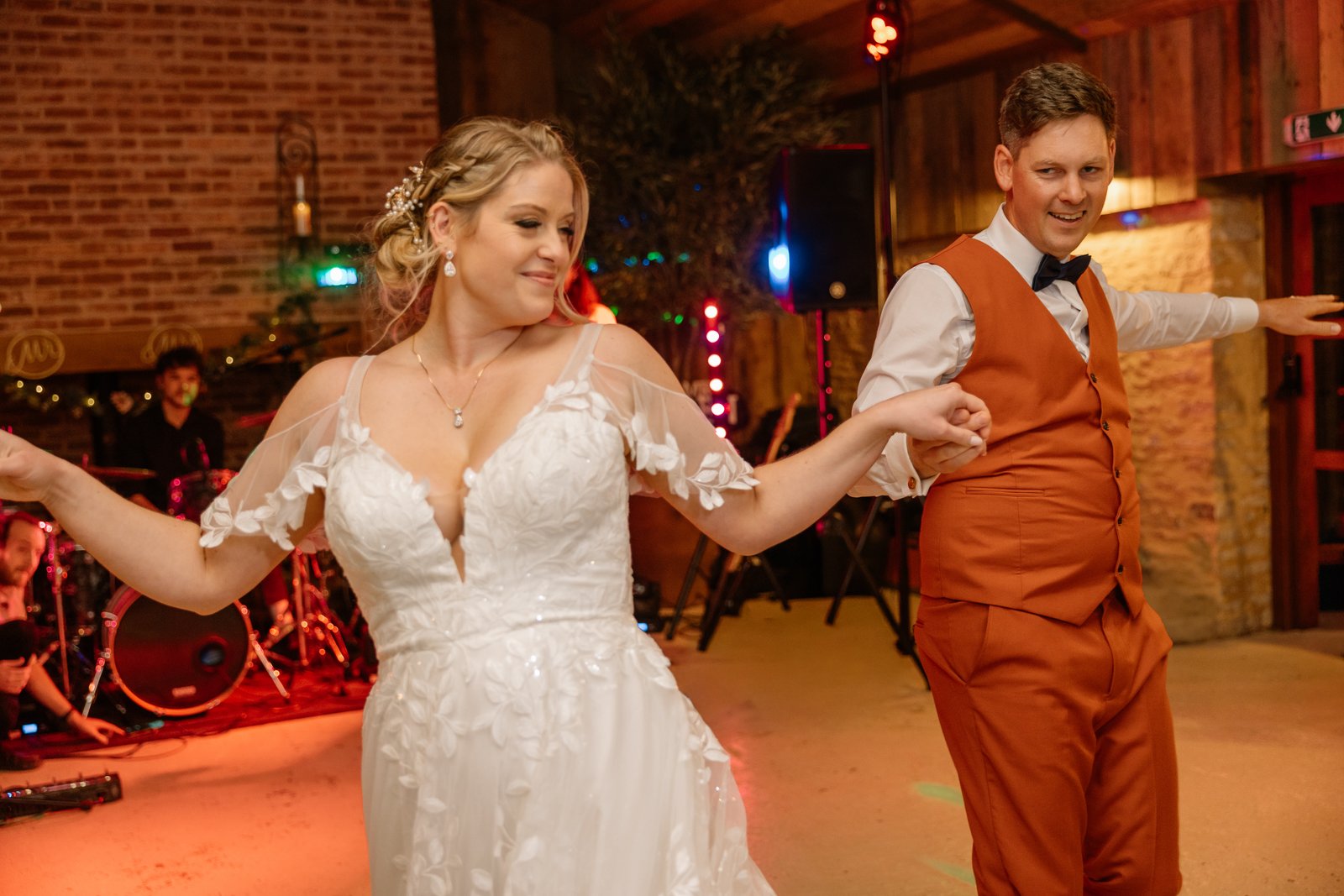 The couple dancing in front of the band under coloured lights at Stratton Court Barn.