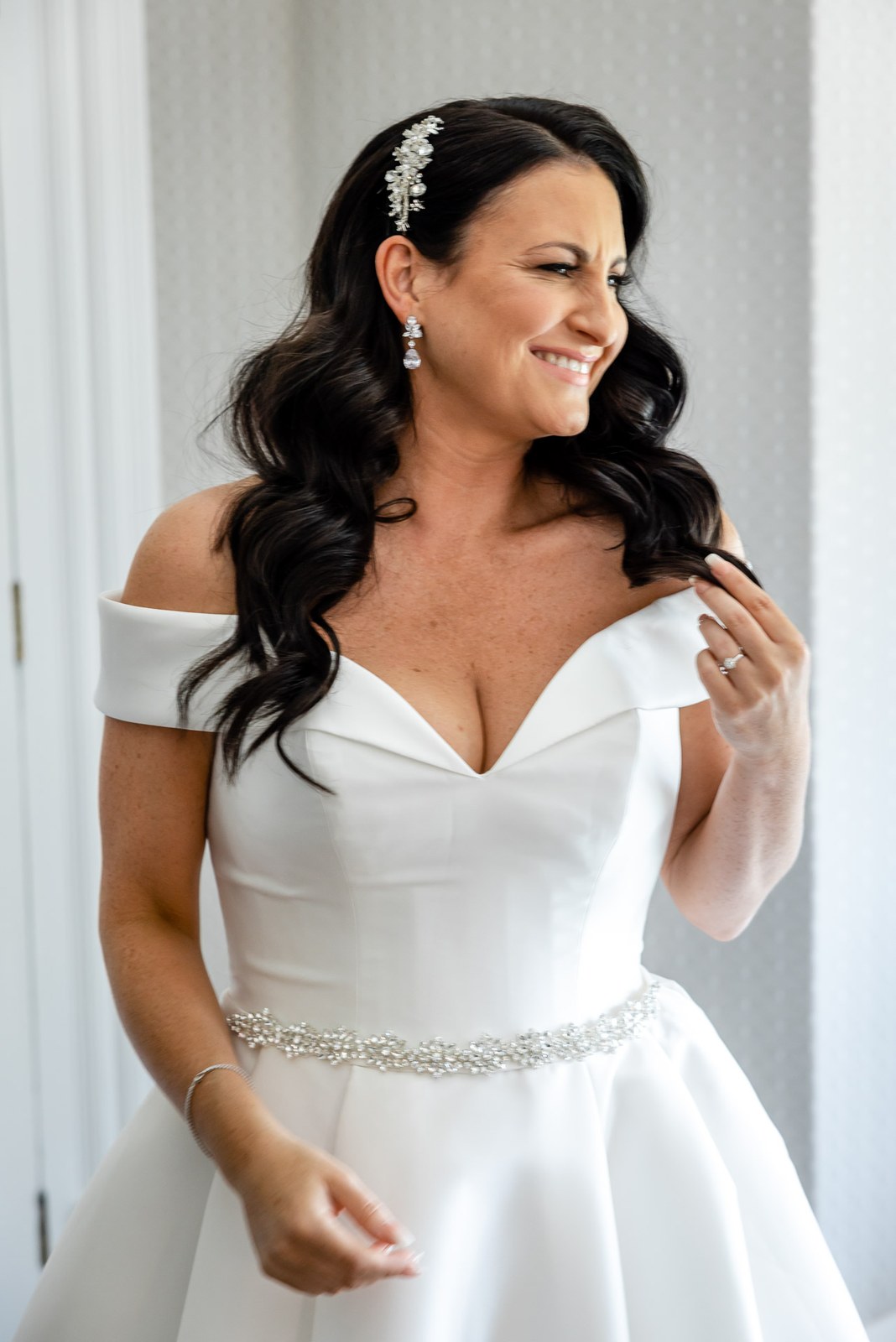 Portrait of the bride in her off-shoulder gown with a jewelled belt