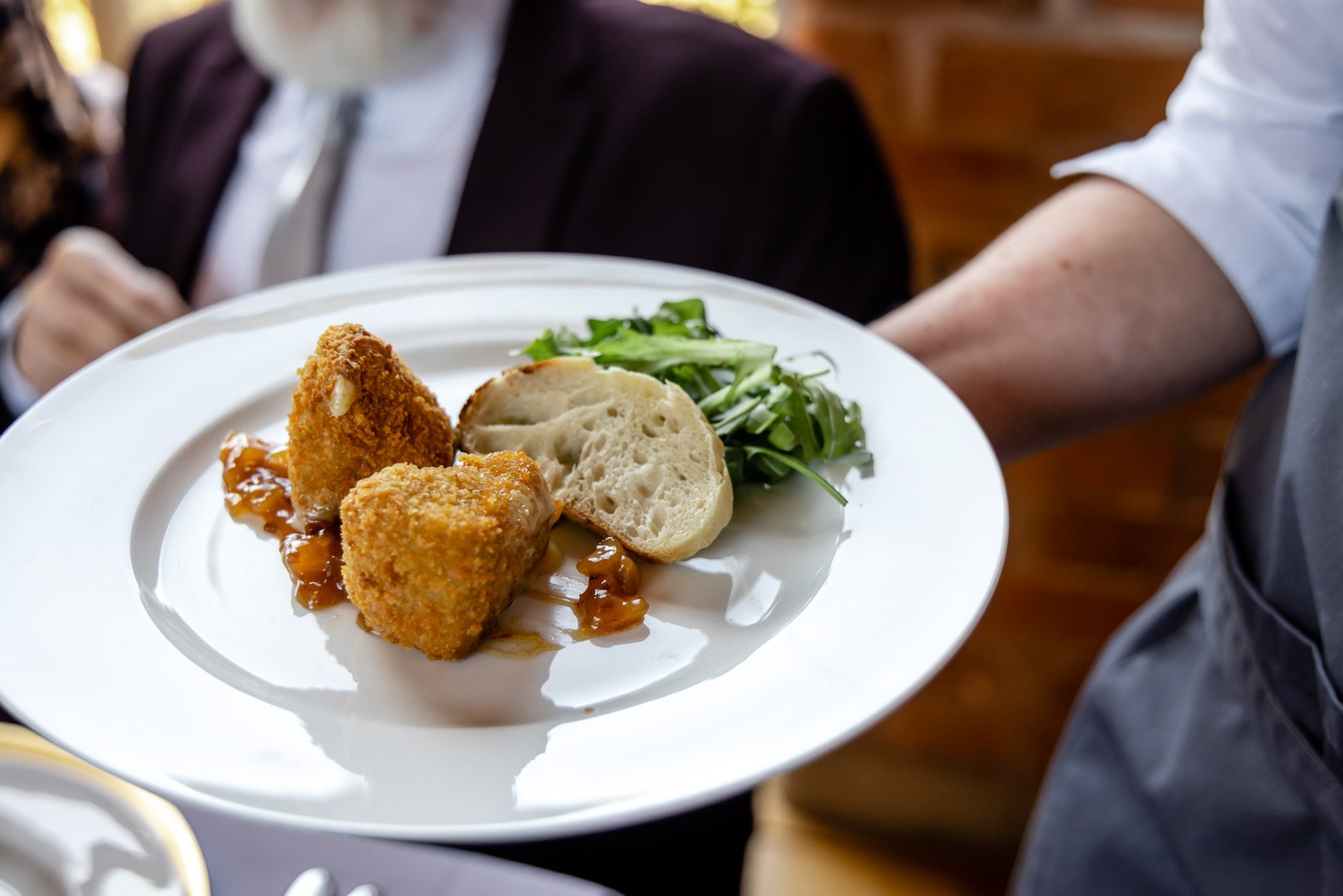 A plated starter of breaded bites with bread and dressed rocket