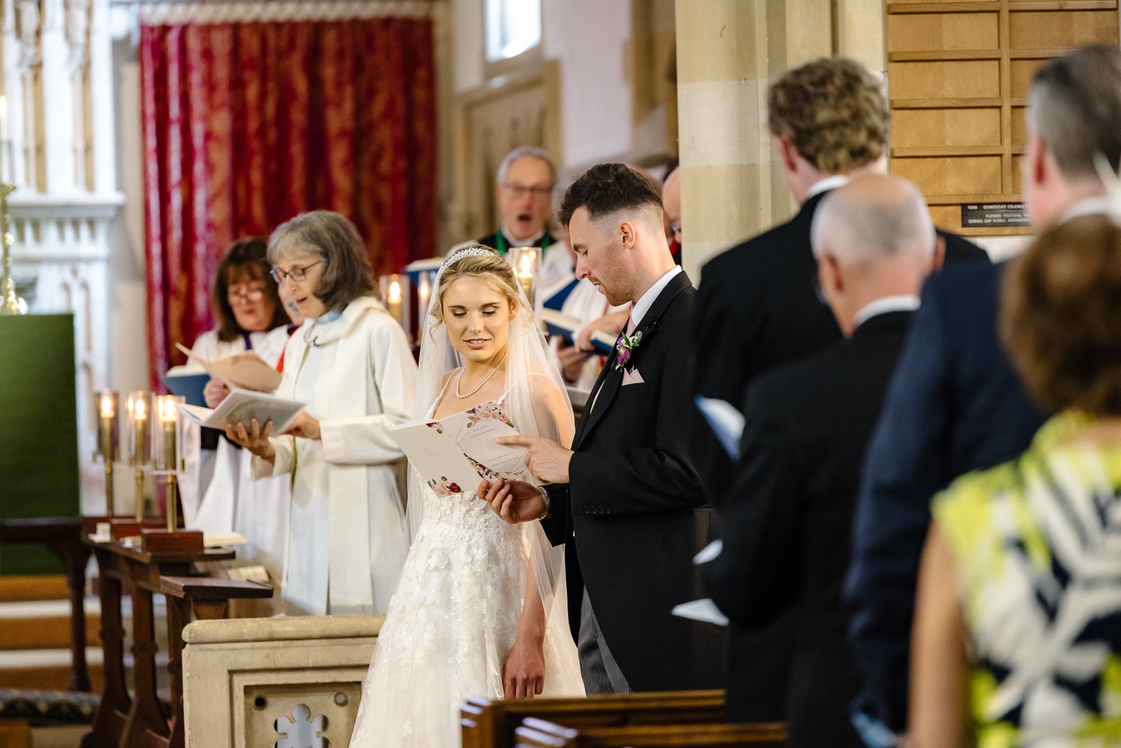The couple during the ceremony surrounded by seated guests