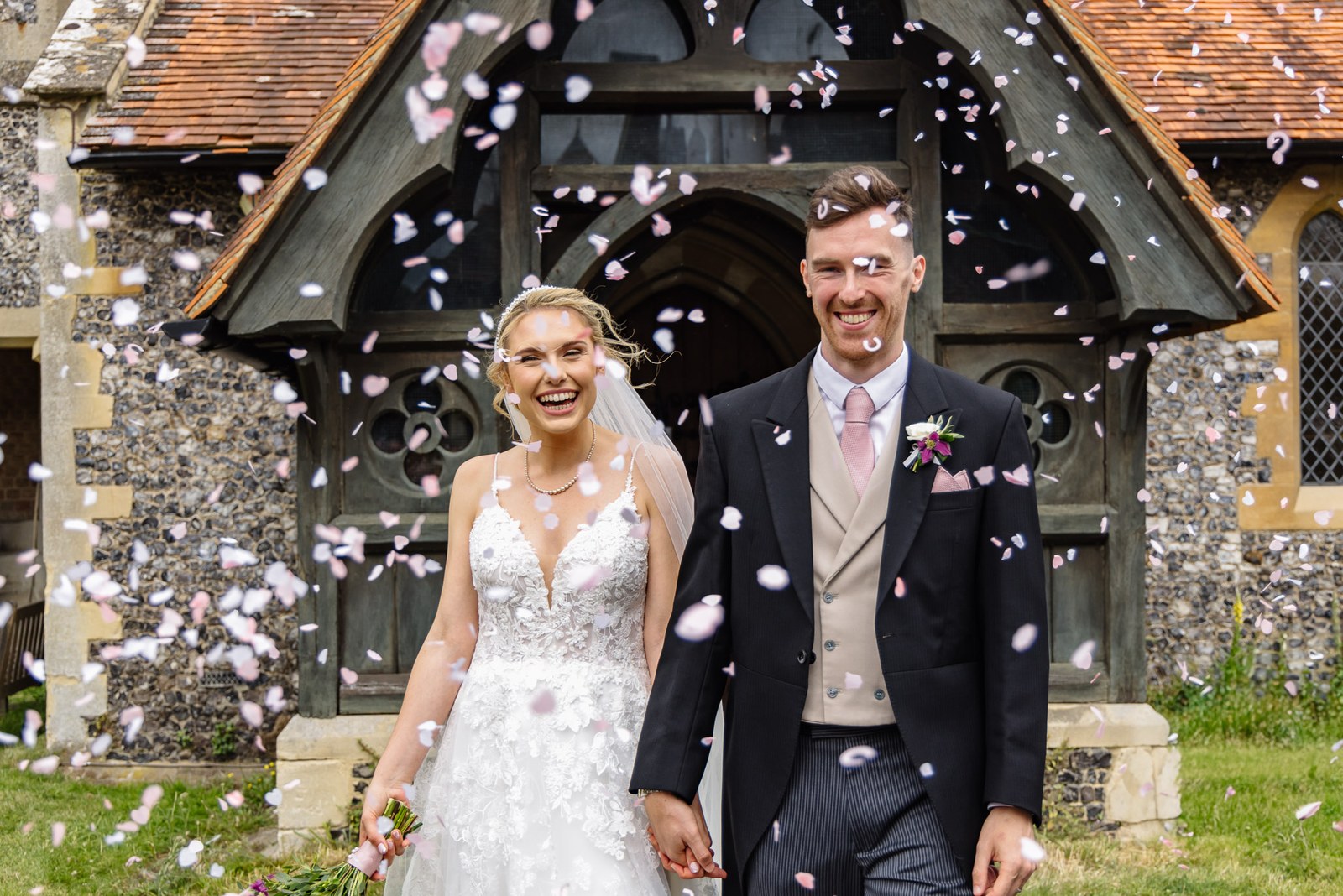 Bride and groom showered with confetti at the church porch
