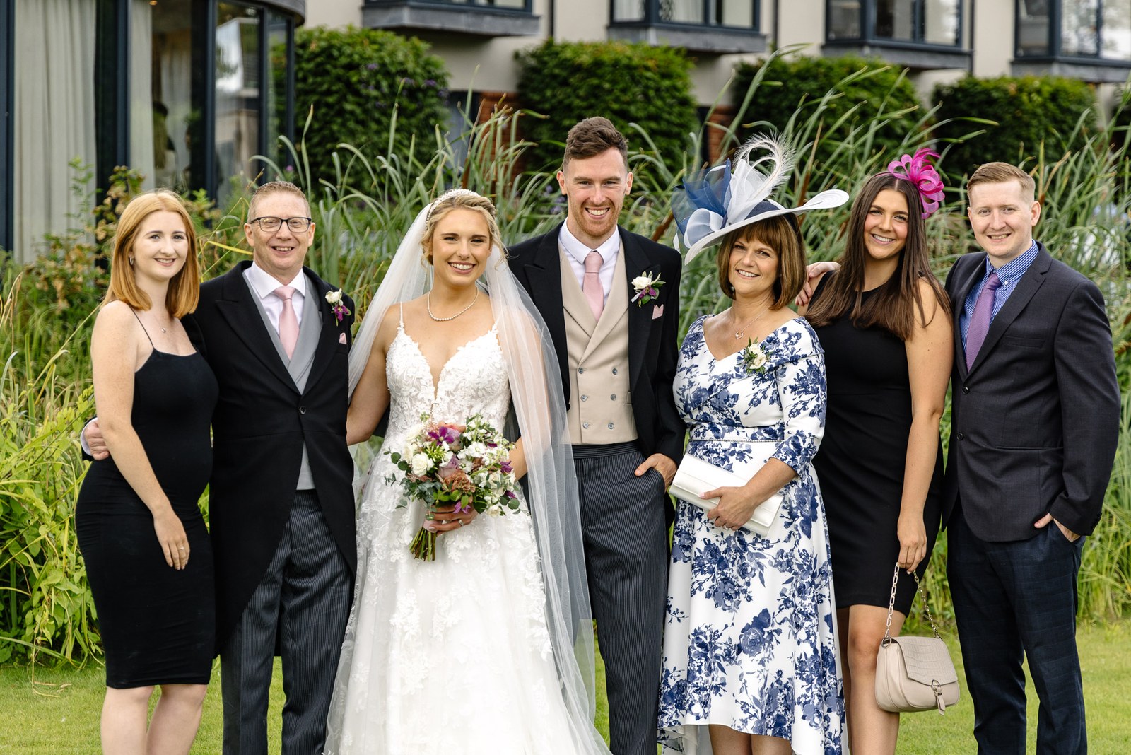 Bride and groom with family gathered by the riverside reeds at The Swan at Streatley
