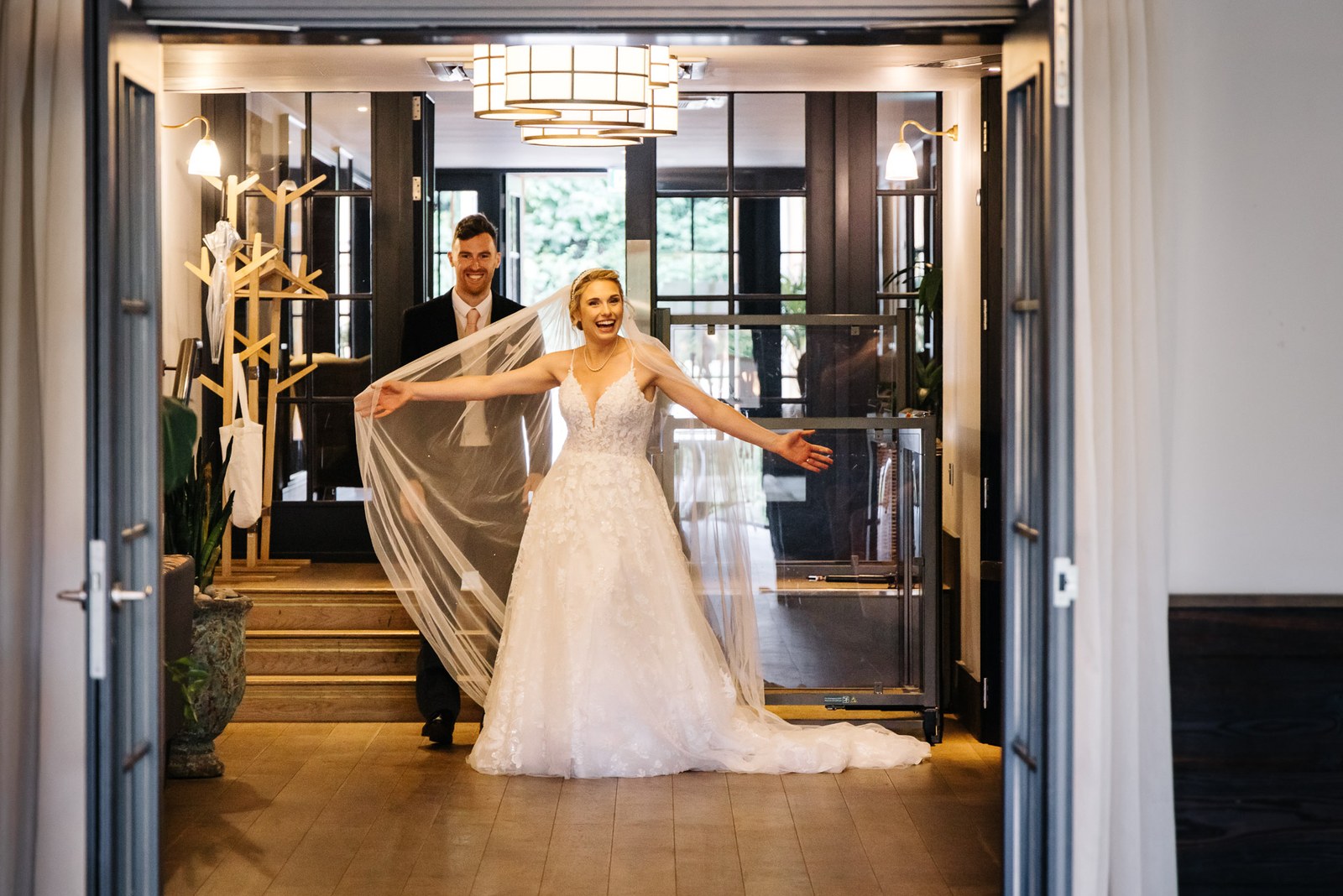 Bride sweeping through the entrance of The Swan at Streatley holding out her veil
