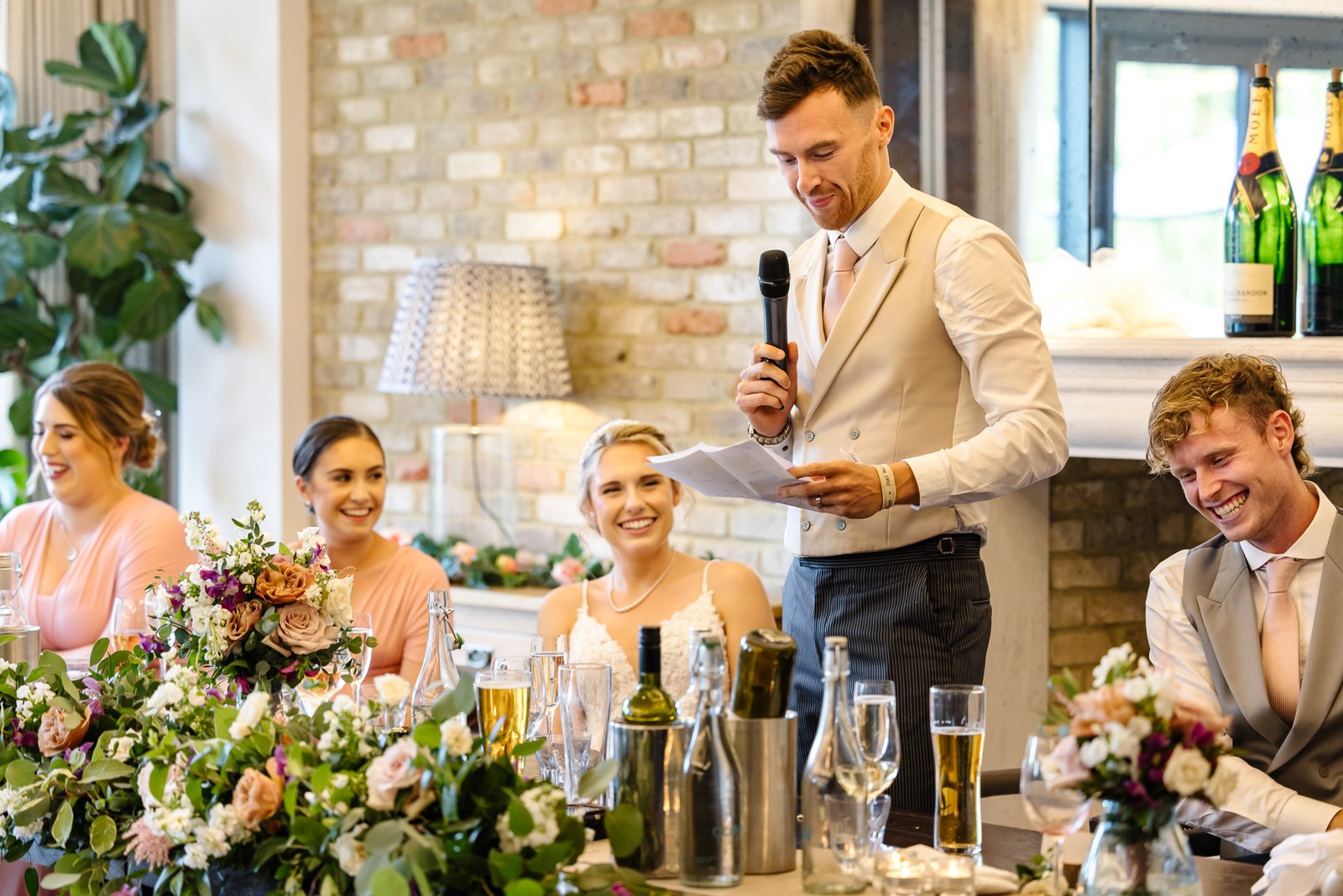 The groom giving a speech as the bridal party watches from the top table