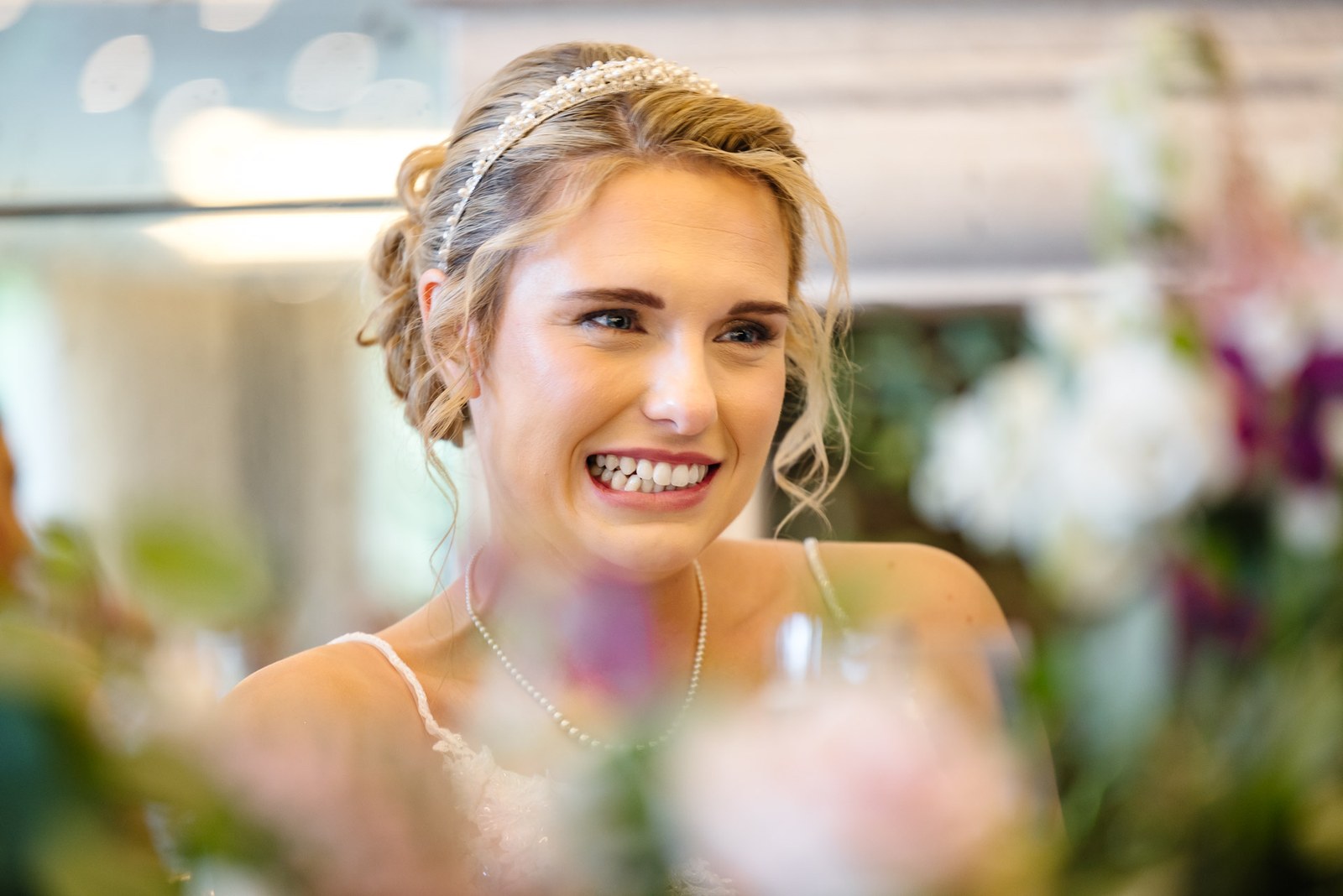 Portrait of the bride smiling, framed by soft flowers