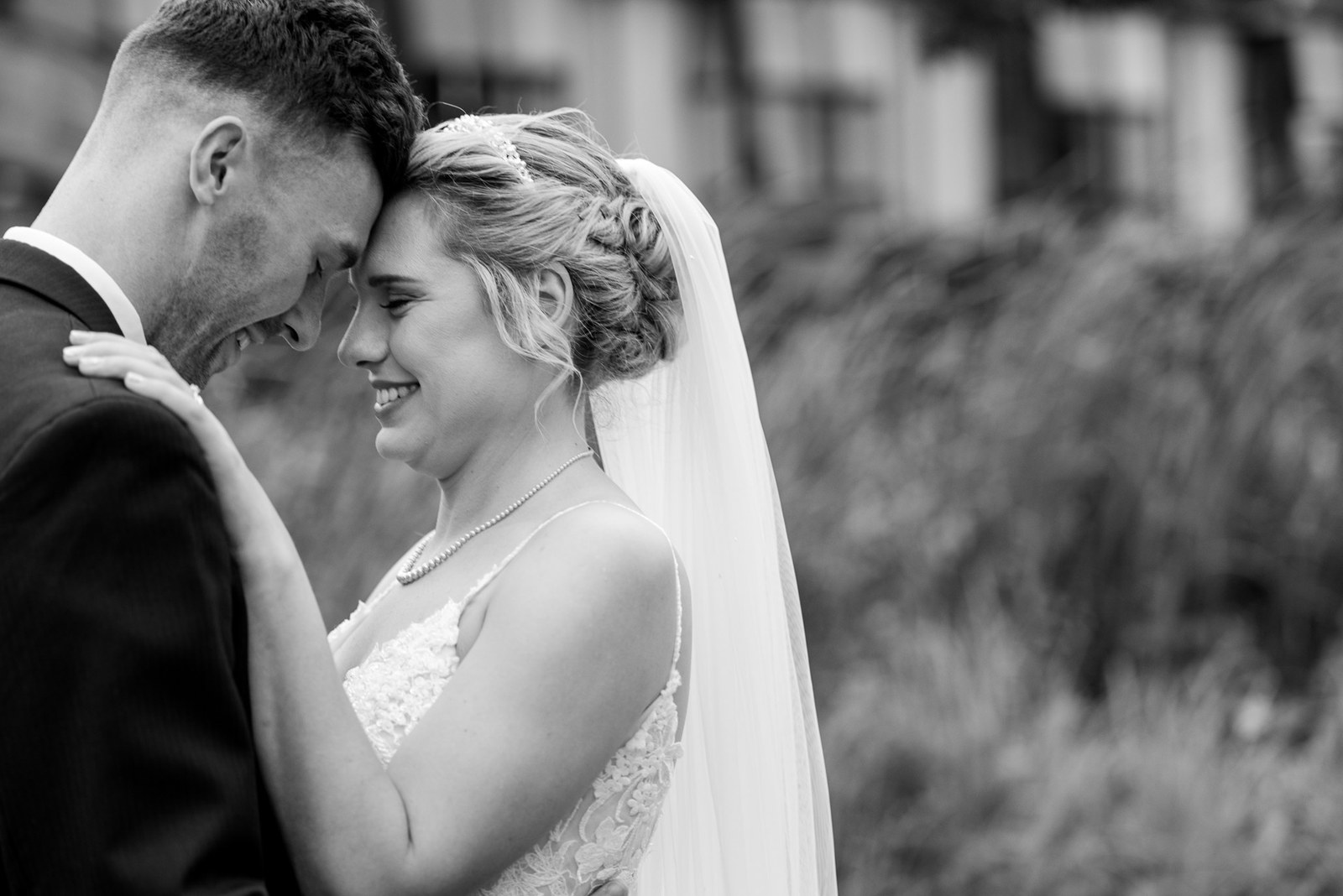 Black-and-white close-up of the couple with foreheads gently touching