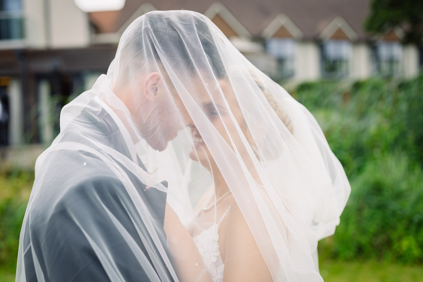 The couple beneath the veil with the gables of The Swan at Streatley behind