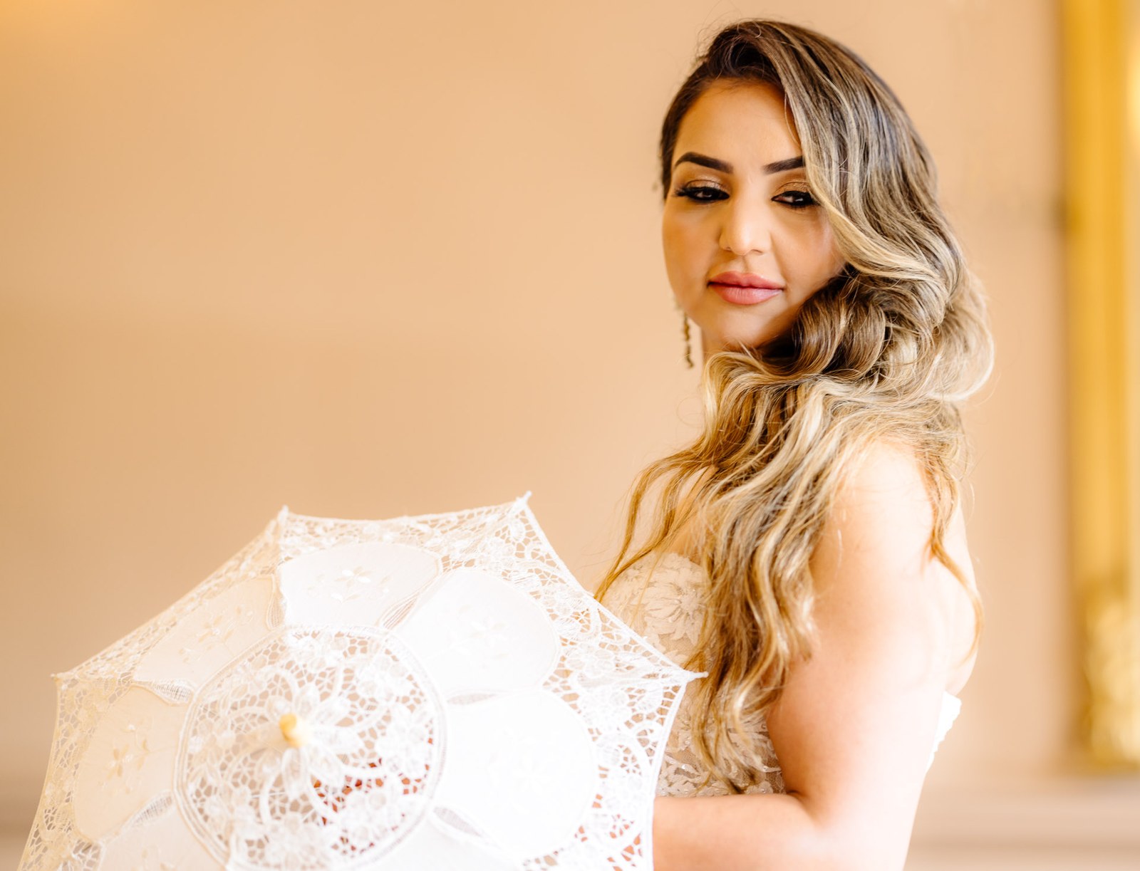 Portrait of the bride holding a delicate white lace parasol