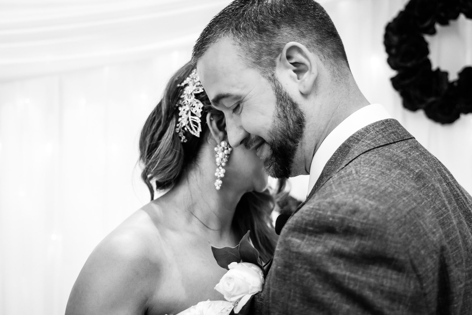 Black-and-white close portrait of the couple leaning their heads together