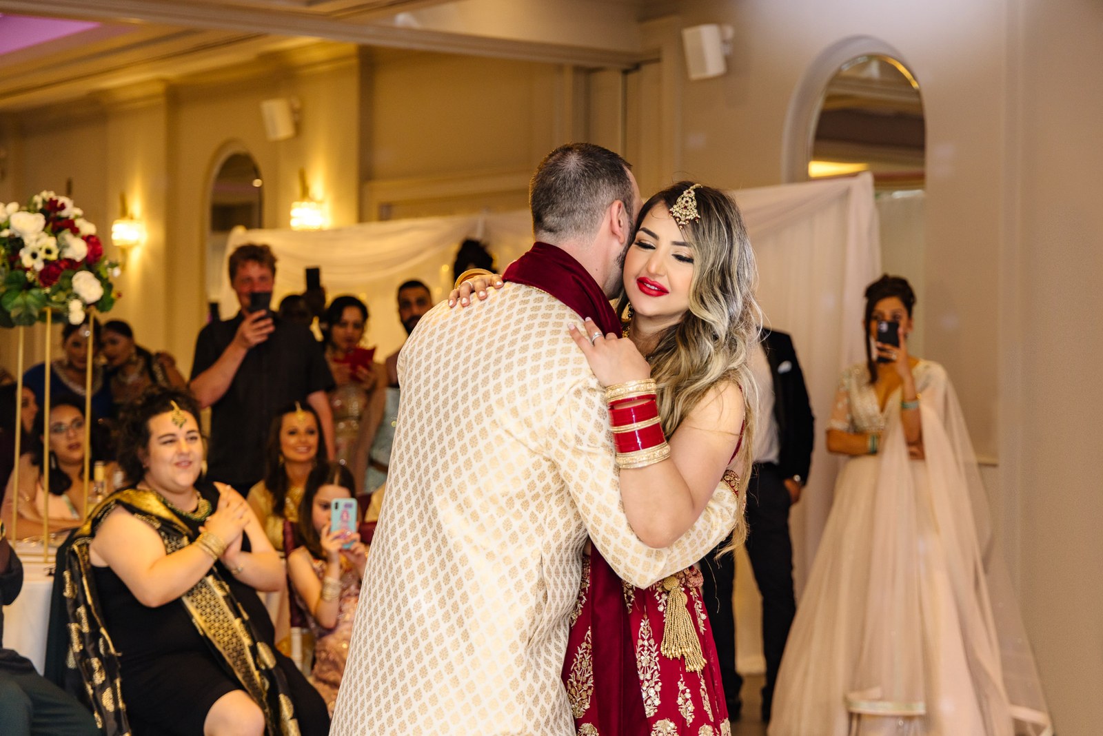 The couple's first dance in Indian dress as guests film the moment