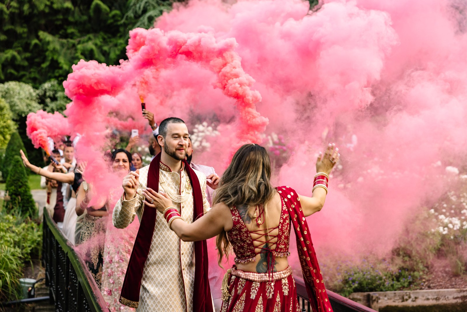 The couple celebrate amid billowing pink smoke on the garden bridge