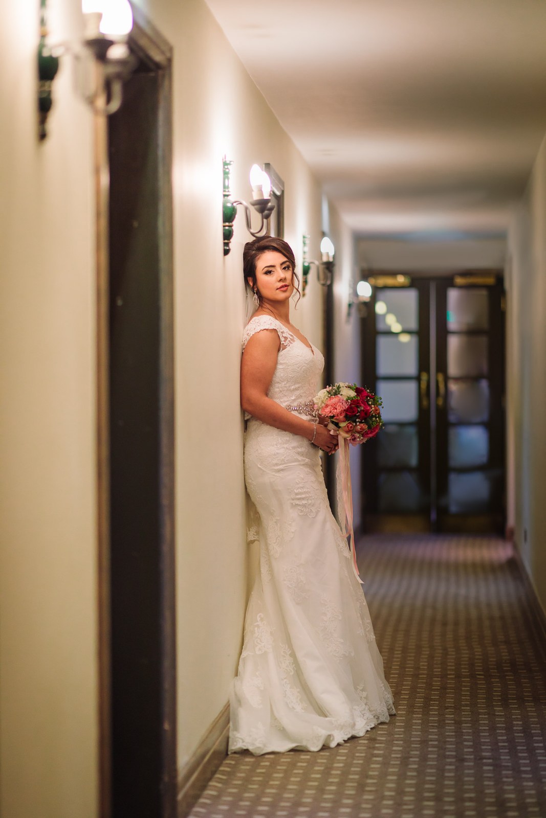 The bride pausing with her bouquet in a corridor at Villiers Hotel