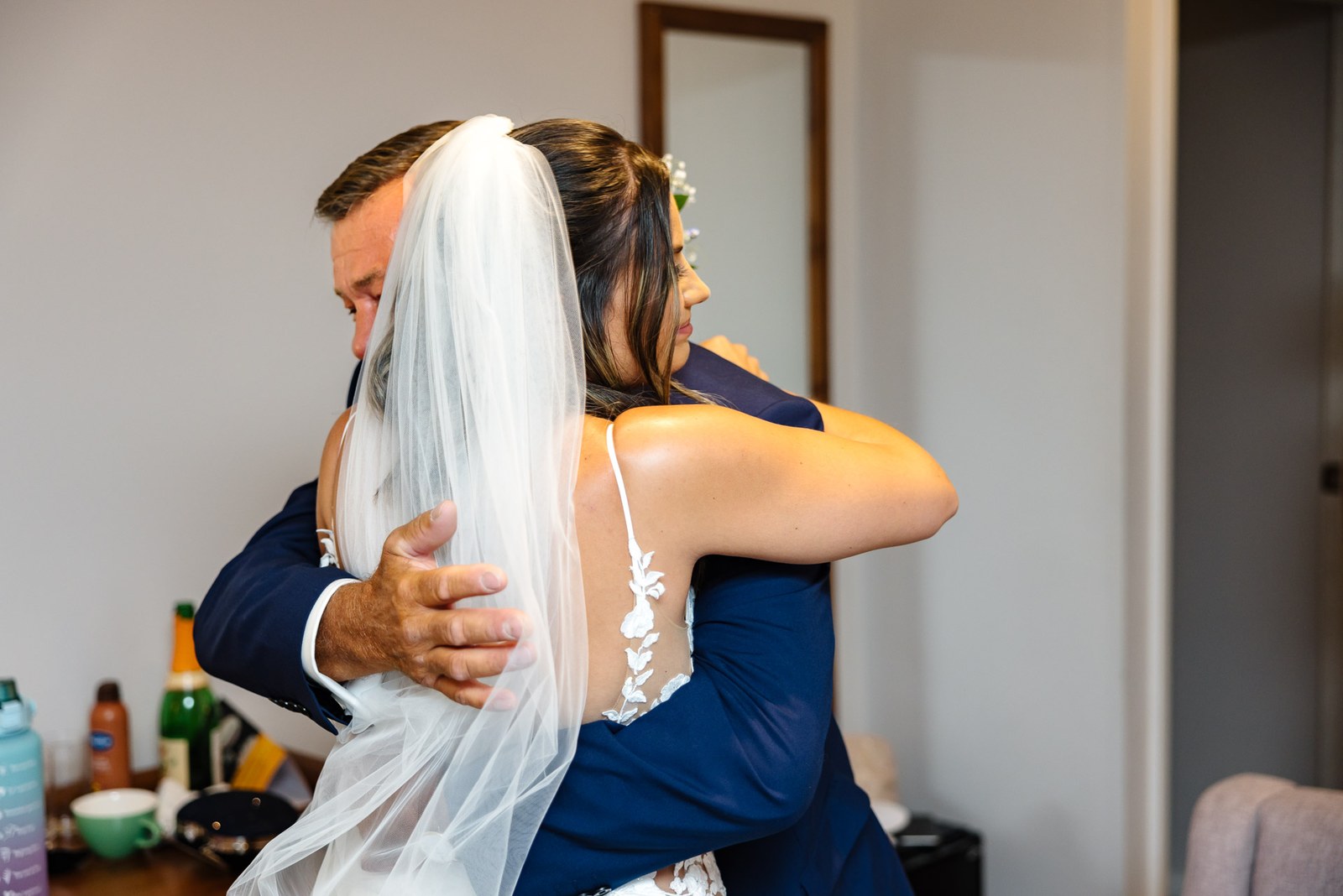 The bride embracing her tearful father in an emotional first look
