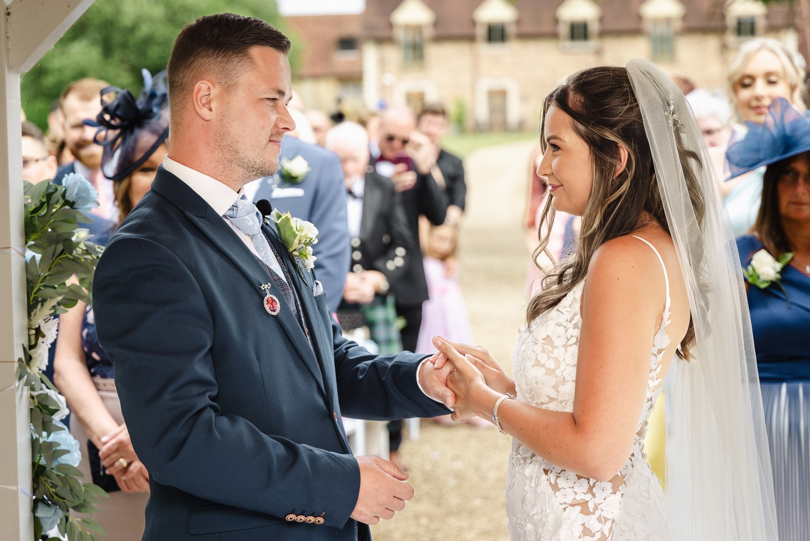 The couple exchanging vows facing each other during the outdoor ceremony
