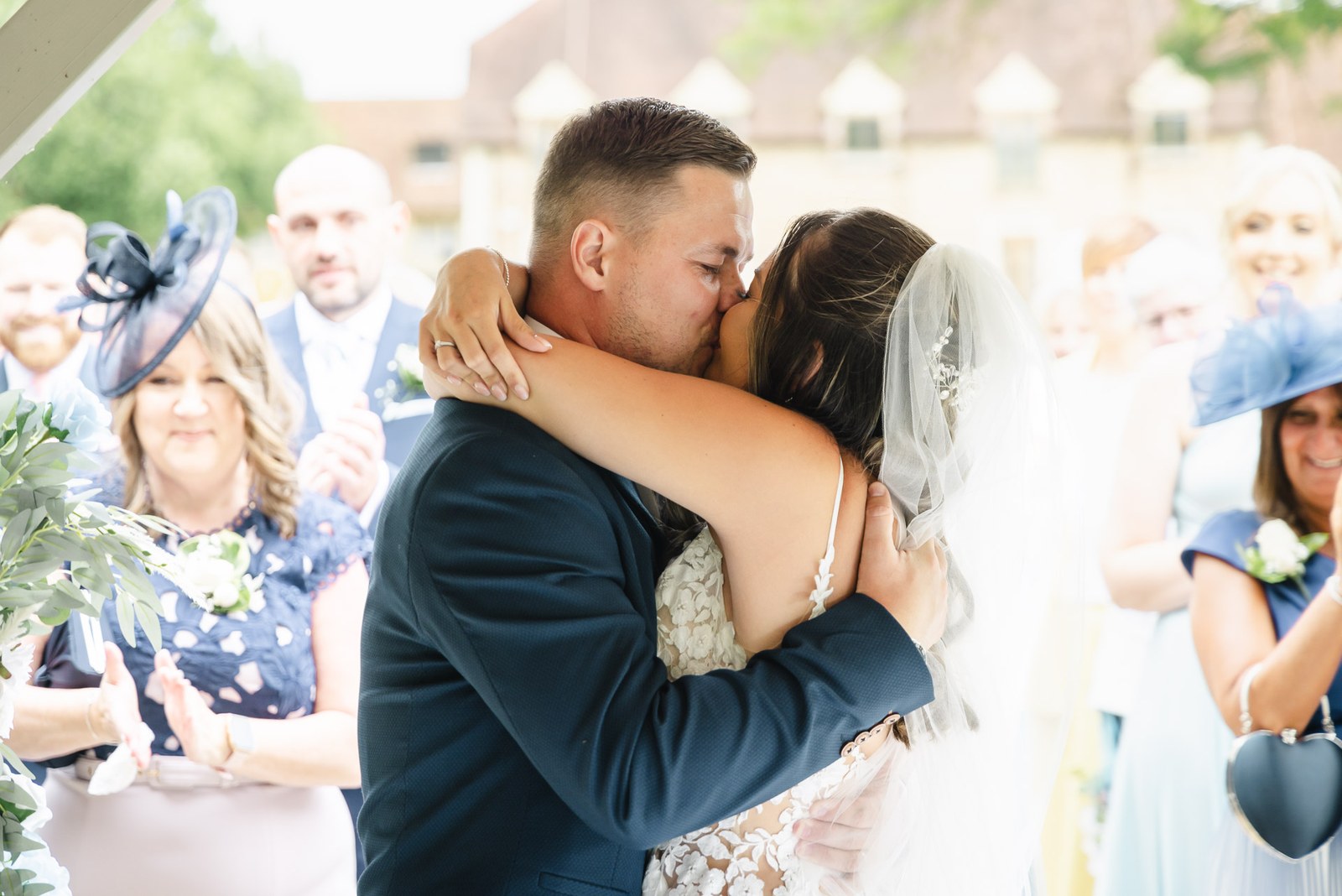 The newlyweds sharing their first kiss as guests applaud