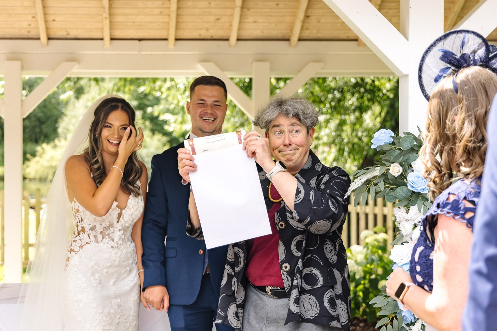 The couple and celebrant holding up the signed marriage certificate