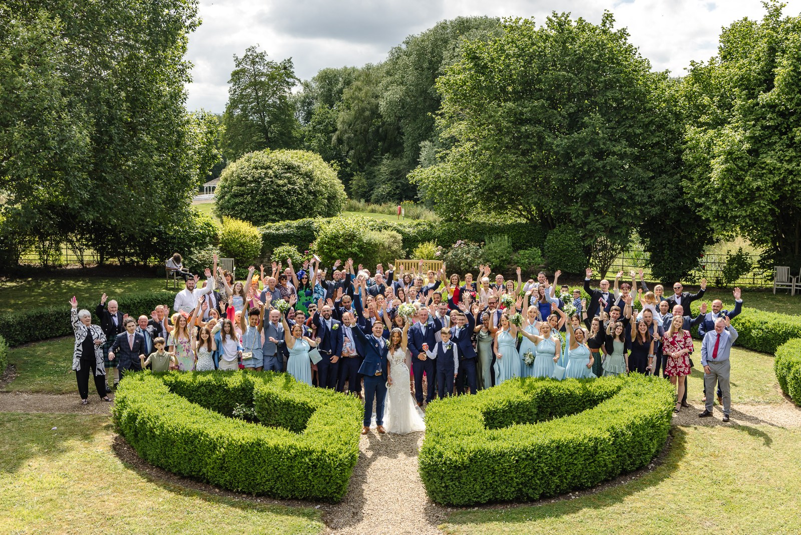 Group portrait of all the guests in the formal gardens at voco Oxford Thames