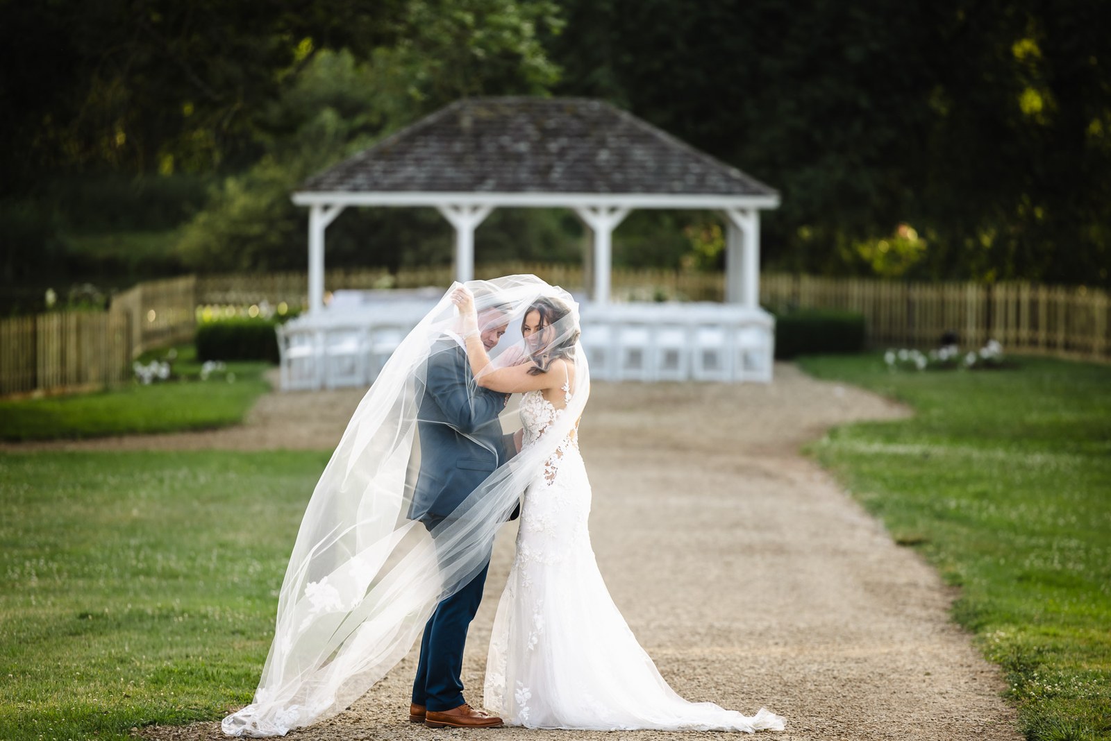 The couple kissing on the path in front of the voco Oxford Thames ceremony pavilion