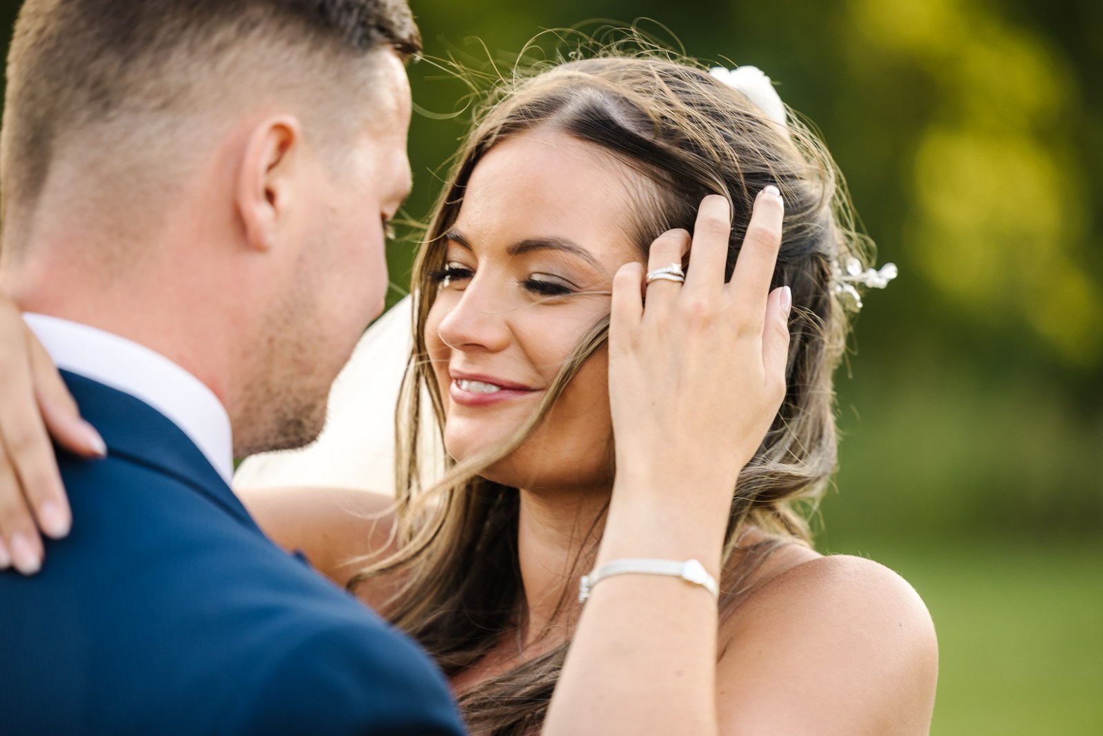 Close-up of the bride touching her hair with her wedding ring on show