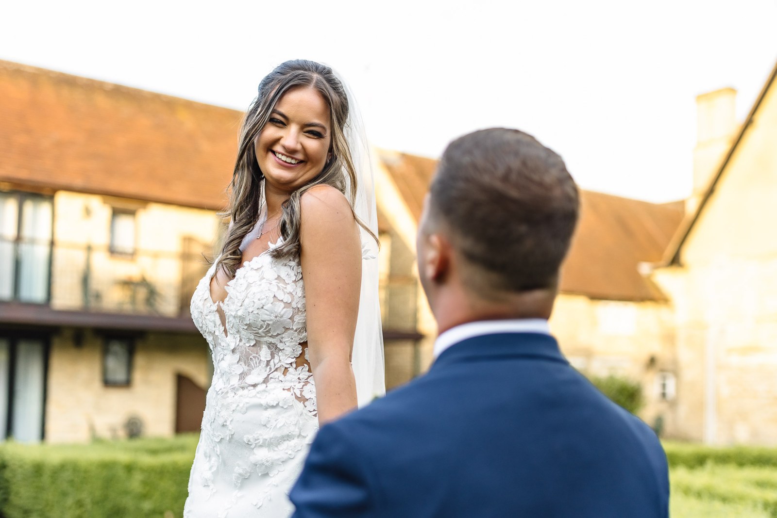 Bride smiling at the groom outdoors with the hotel behind them