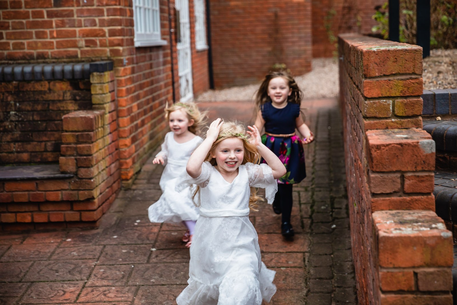 Flower girls running along the brick path beside Windmill Village Hotel
