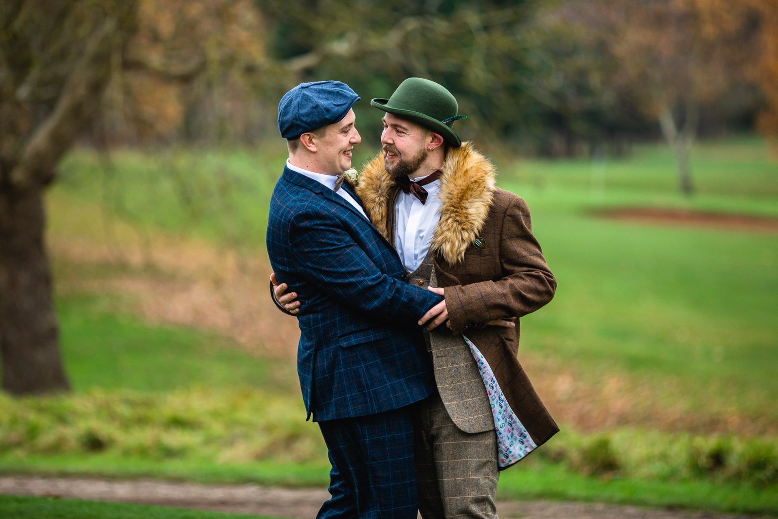 The two grooms embracing on the autumn grounds of Windmill Village Hotel