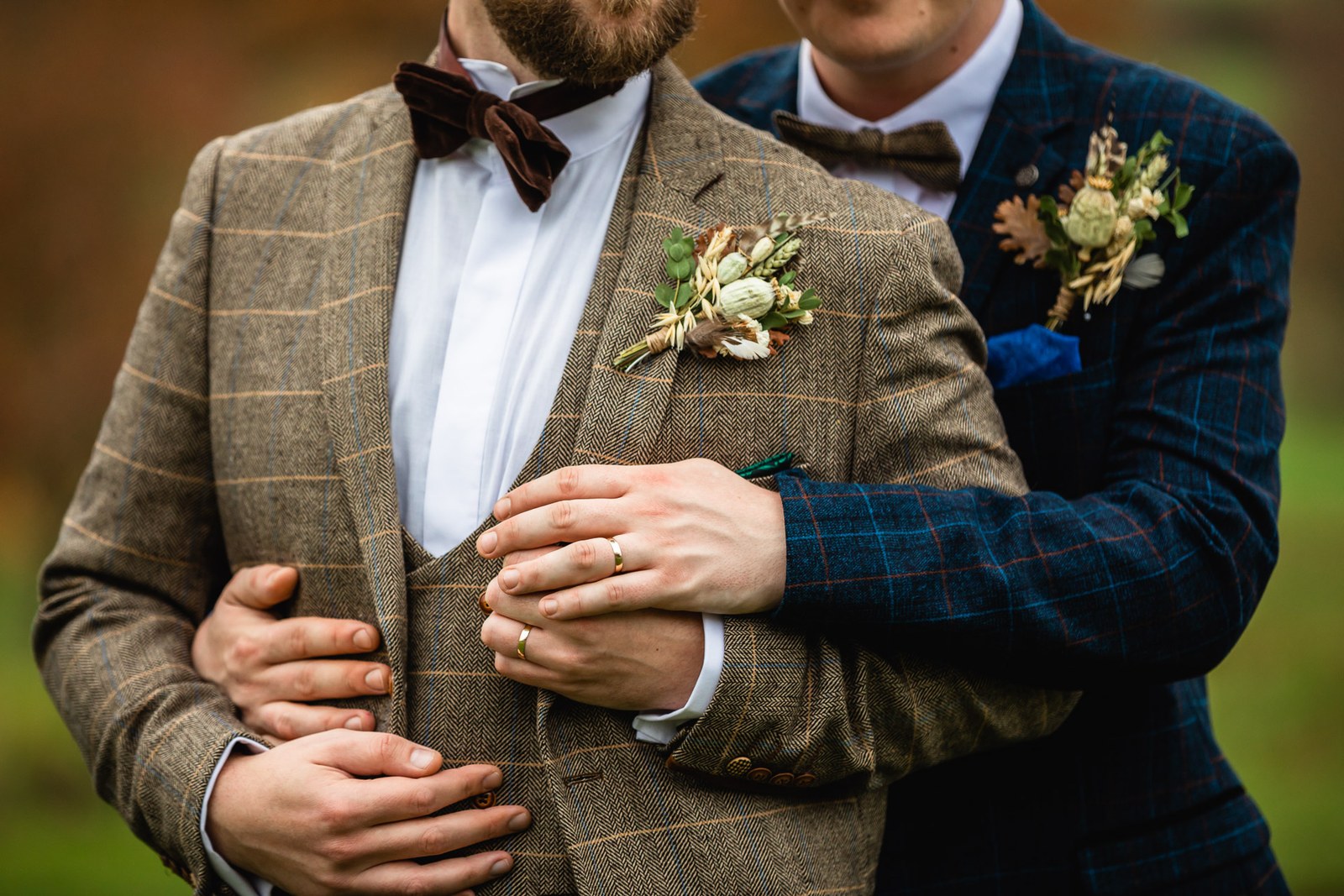 Close-up of the grooms embracing with a wedding ring on show