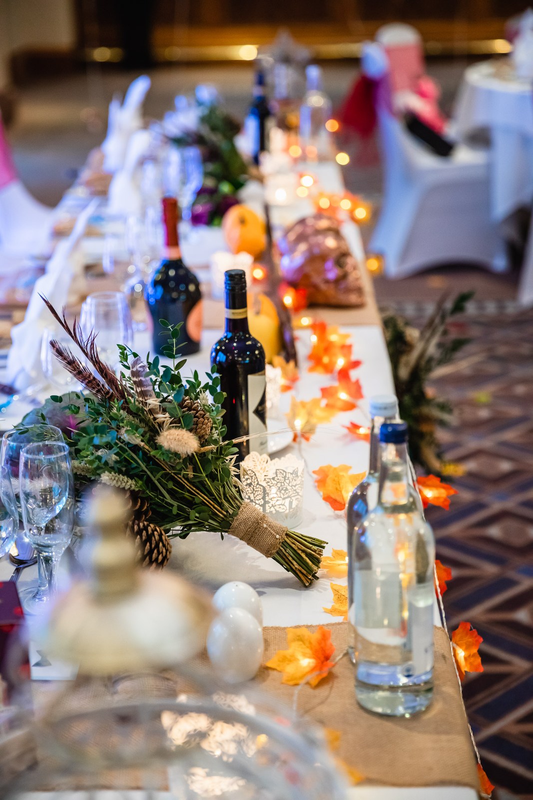 The long top table at Windmill Village Hotel dressed with autumn foliage and candlelight