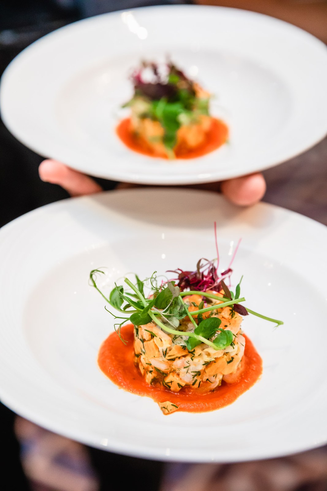 Waiter presenting two plated starters at the wedding breakfast