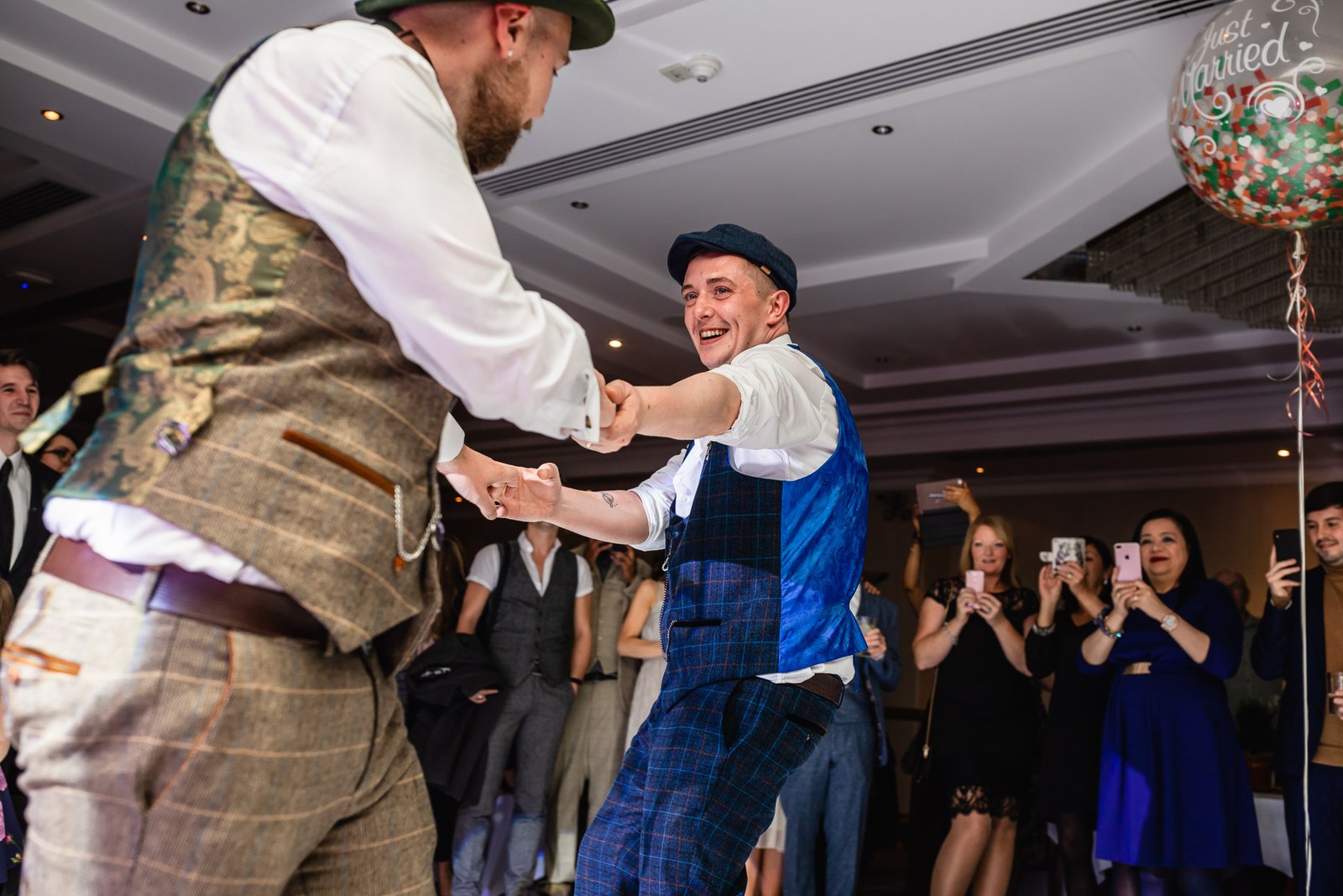 The grooms dancing energetically together on the dance floor