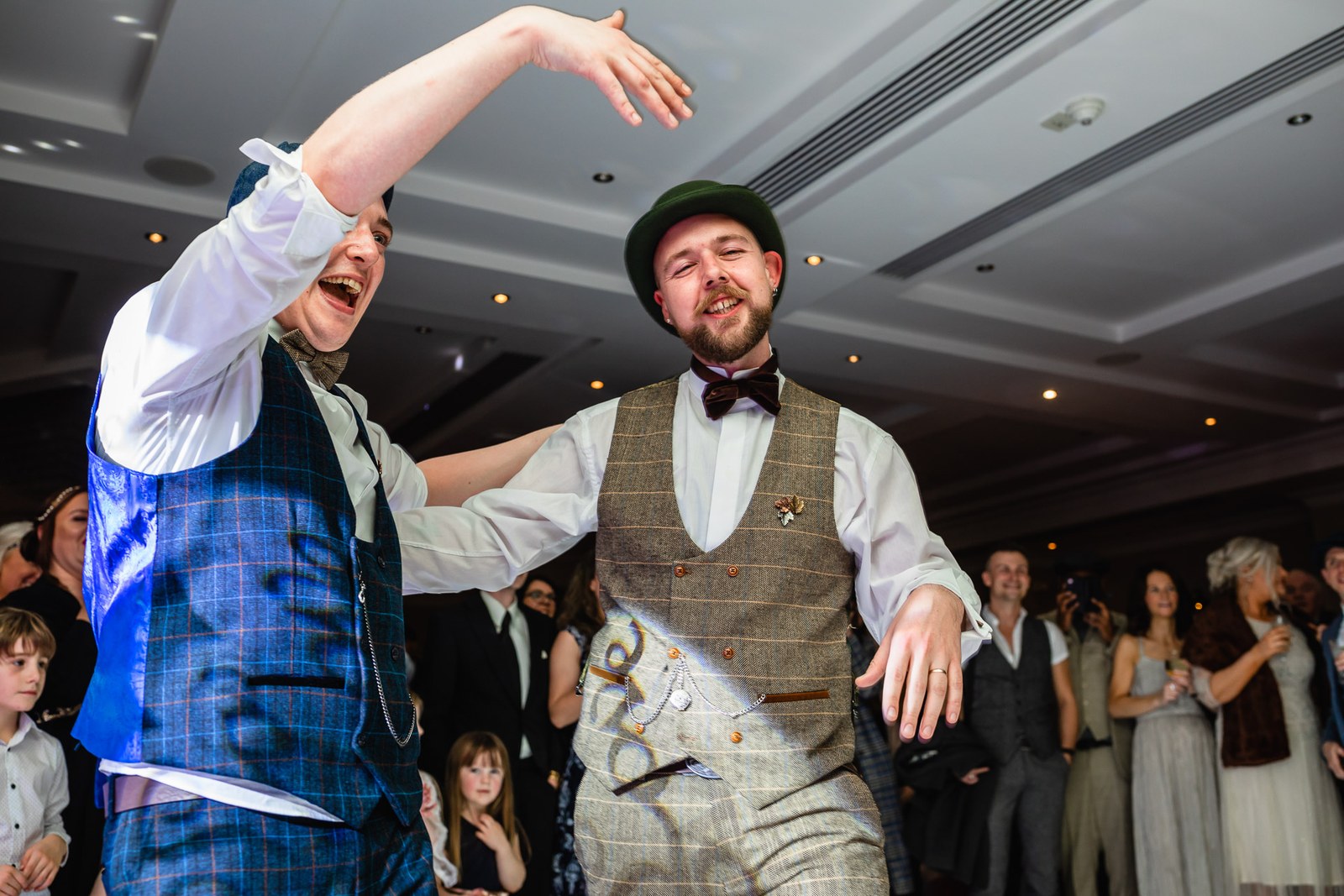 The grooms dancing exuberantly together on the dance floor