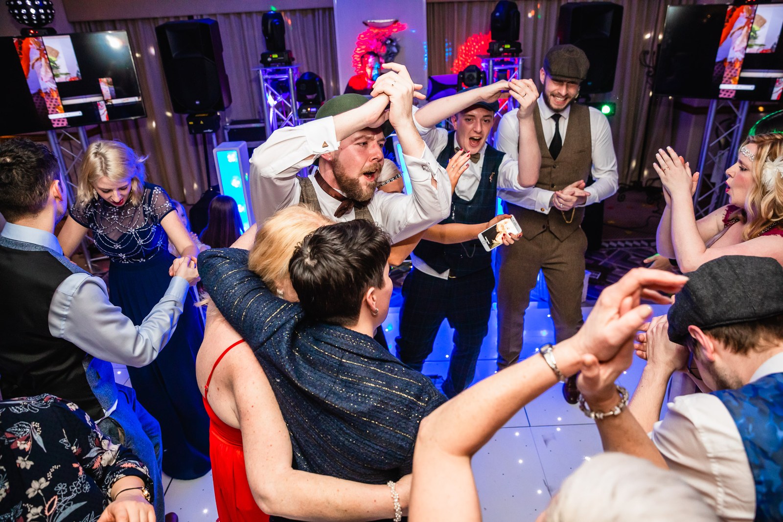 Guests filling the dance floor under colourful lighting