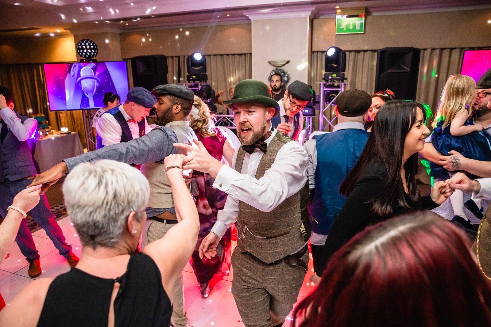 A groom dancing amid guests on the packed dance floor