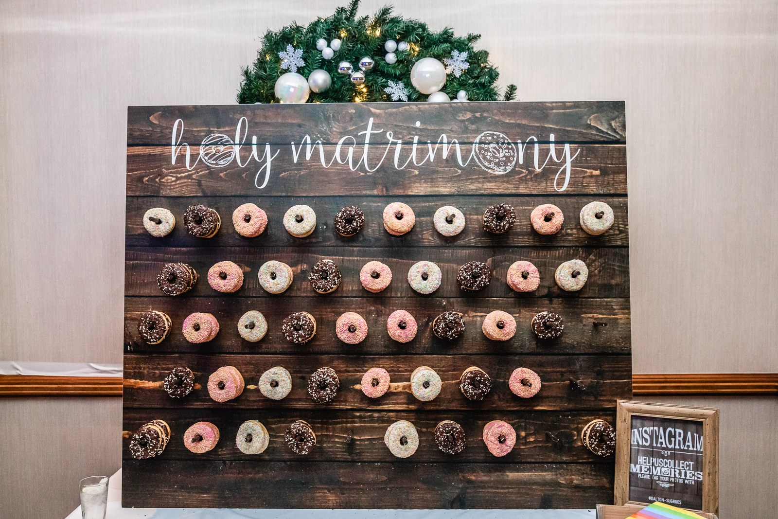 A doughnut wall dessert display beneath a hand-lettered sign