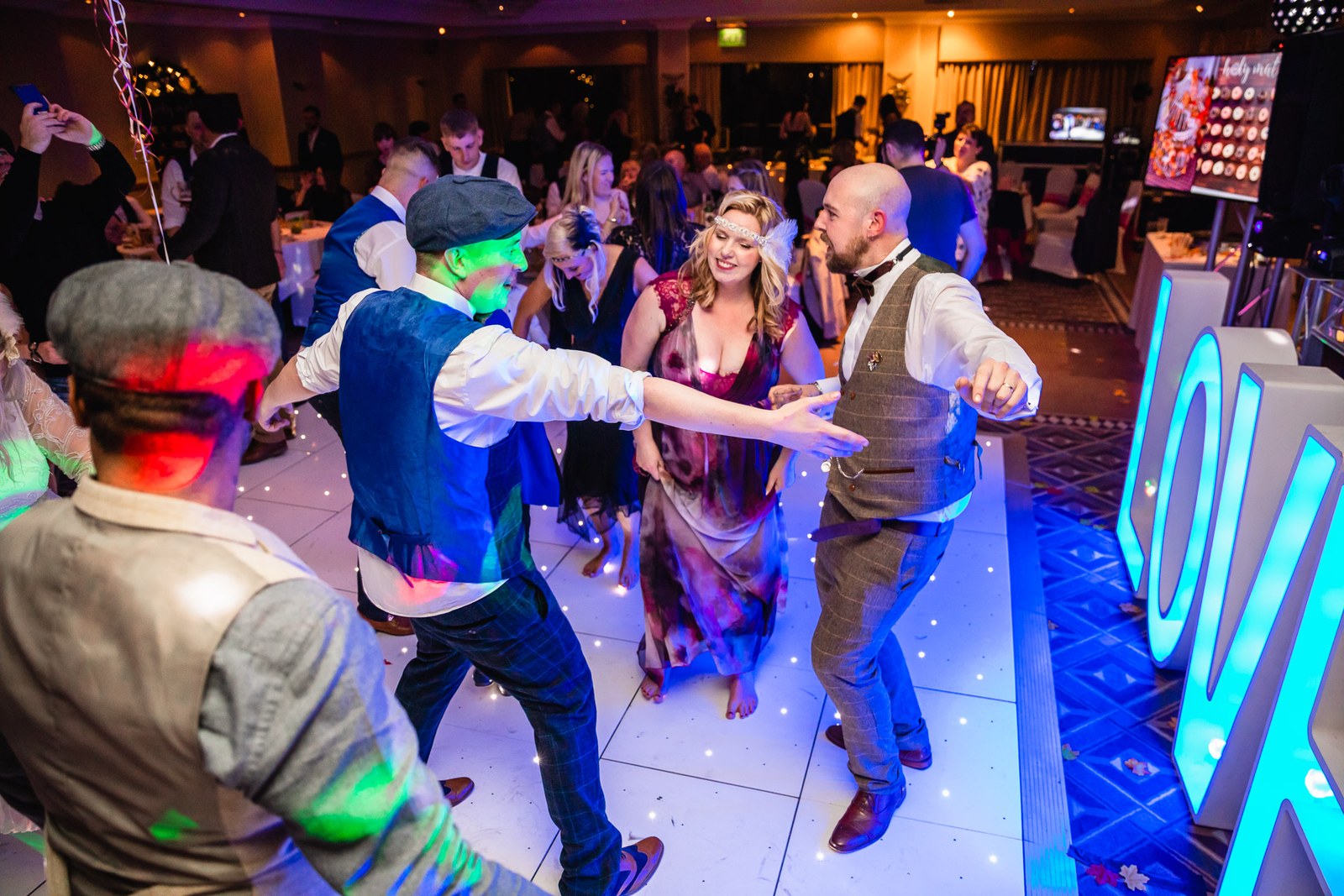 Guests dancing on the light-up floor beside the illuminated letters